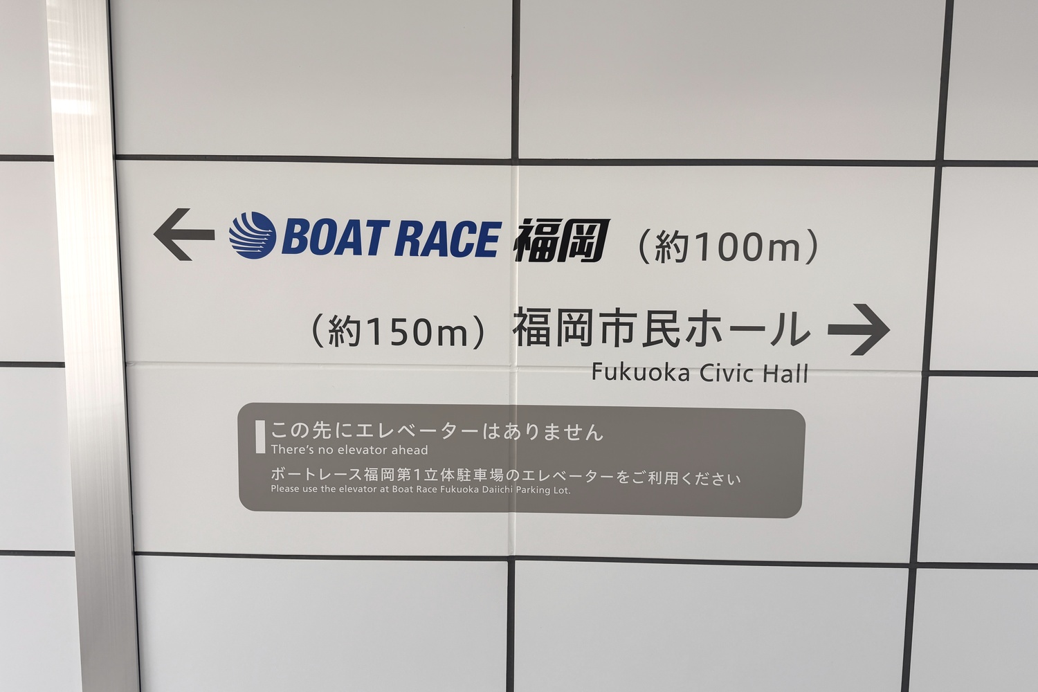 ボートレース福岡第1立体駐車場の通路にあるボートレース福岡と福岡市民ホールへの案内